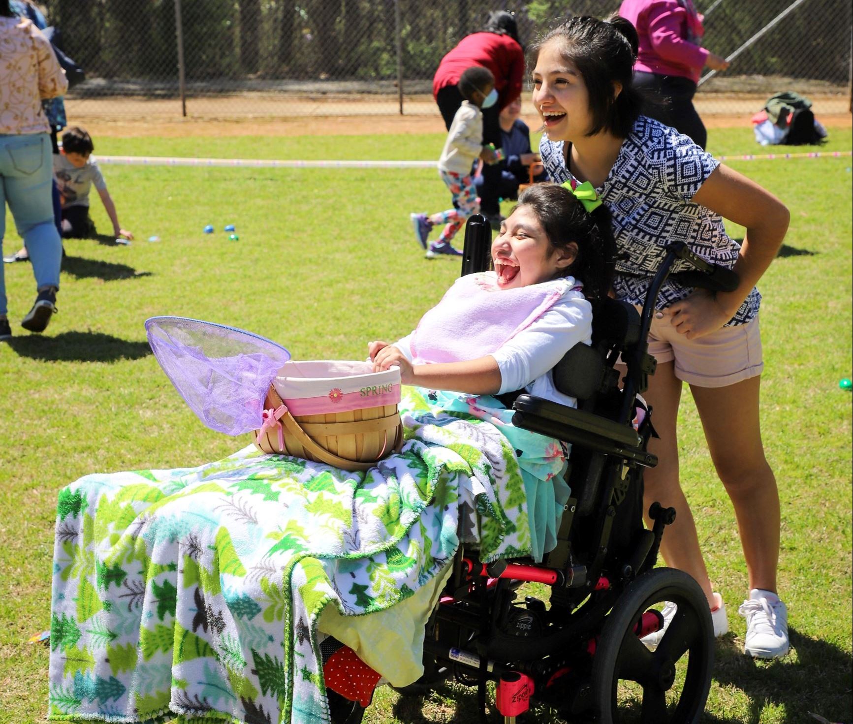girl in wheel chair races to collect eggs at easter egg hunt for special needs kids